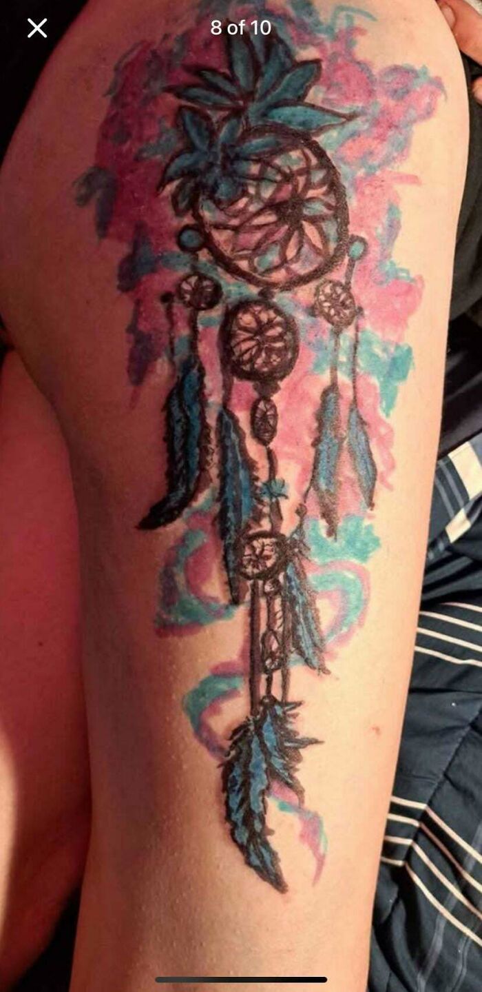 Tattoo fail of a blurry dreamcatcher with pineapple on upper arm