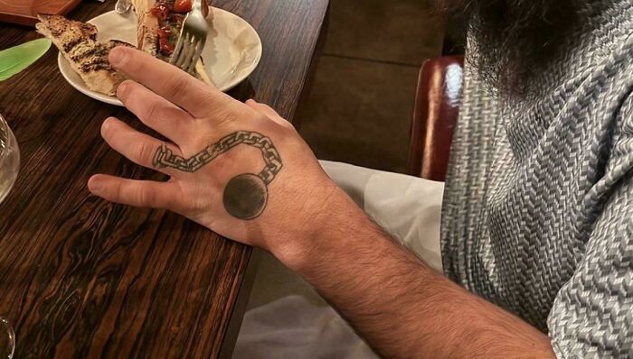 Hand tattoo of a ball and chain with an awkward design tattoo fails