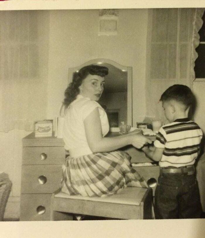 Vintage photo of a woman and child in a kitchen, capturing moments from decades ago that still speak louder today.