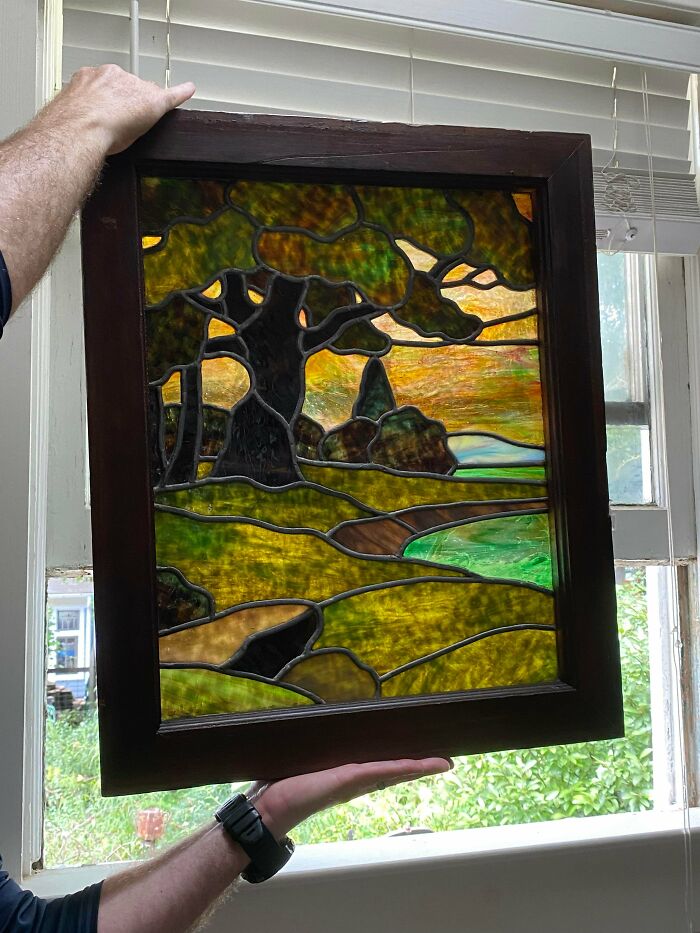 A beautiful stained glass panel with a vibrant landscape design, showcasing remarkable antique artistry.