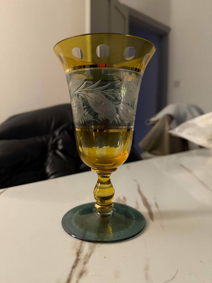 A remarkable antique glass goblet with a gold rim and base, featuring frosted leaf engravings around the center.