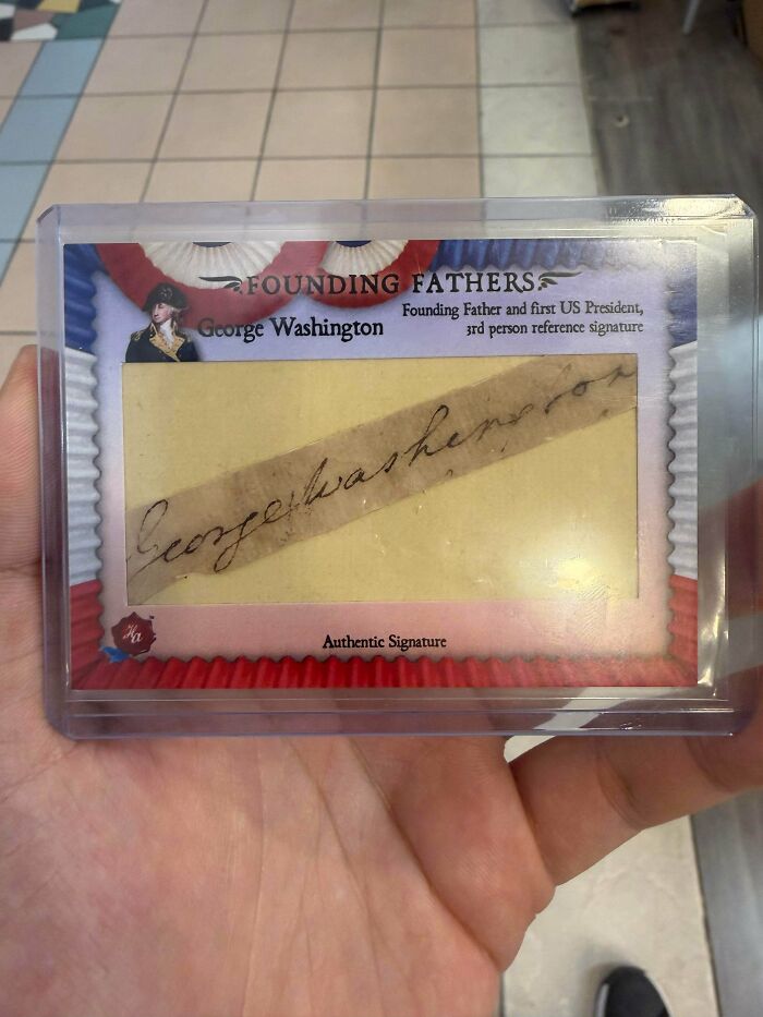 A hand holding a clear case containing a remarkable antique, George Washingtons authentic signature.