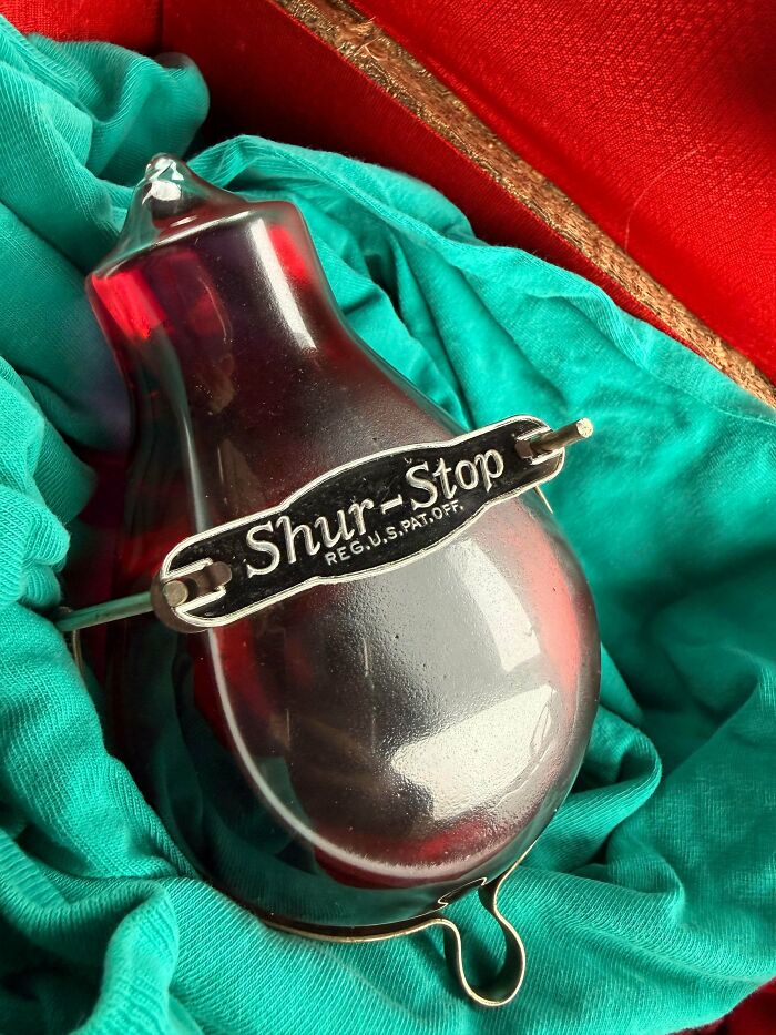 Remarkable antiques: A vintage red glass Shur-Stop fire extinguisher in its original packaging.