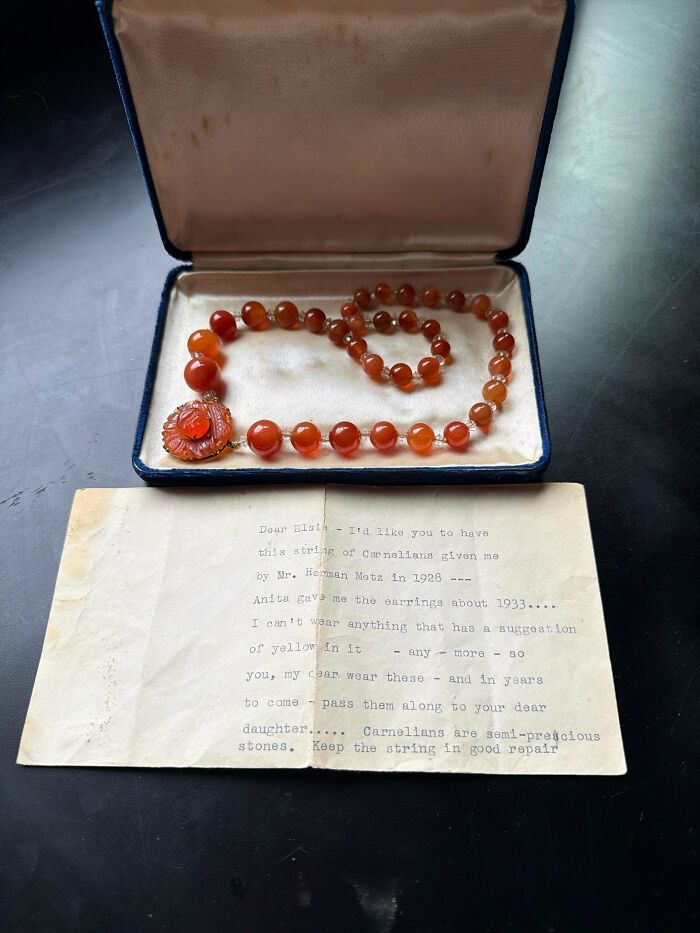 An open blue velvet box displays a beautiful string of orange carnelian beads, a remarkable antique find.