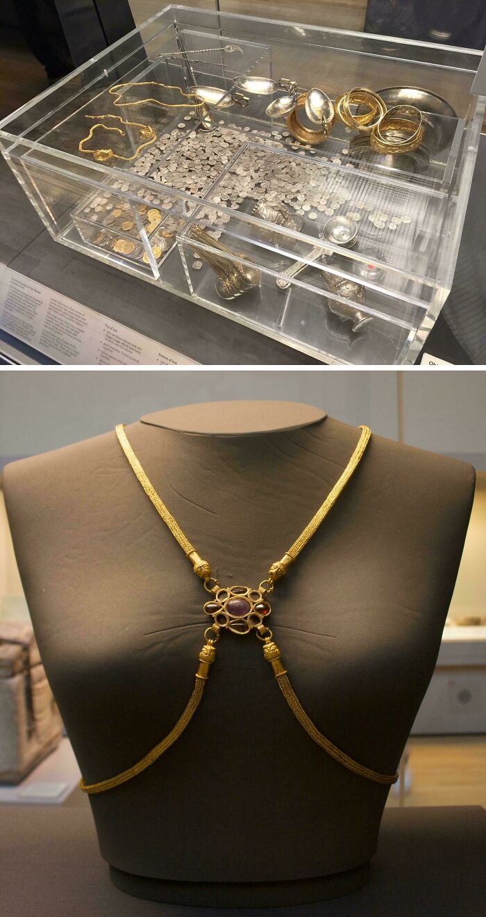 Display of ancient gold and silver coins and jewelry in a museum exhibit case