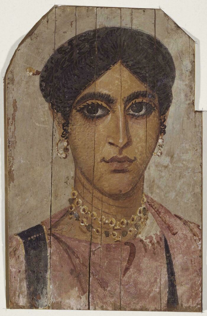 Ancient painted wooden panel portrait of a woman with jewelry from a historical era