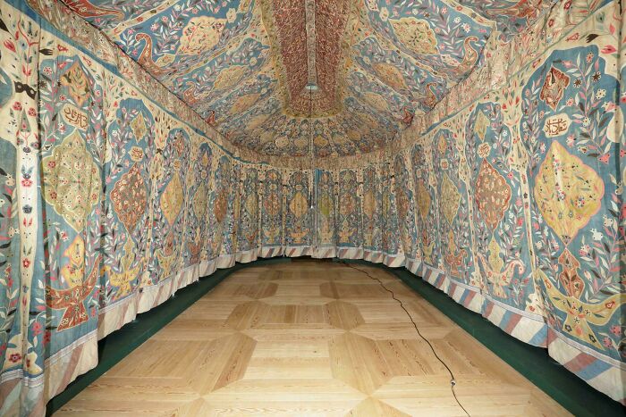 Colorful embroidered textile tent interior showcasing detailed historic fabric patterns