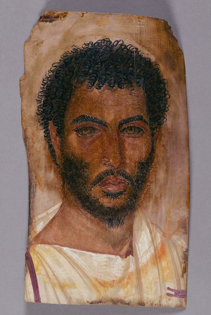 Fayum mummy portrait depicting a man with curly hair and beard on wooden panel