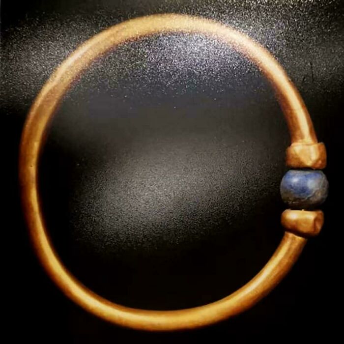 Ancient gold bracelet discovery with blue bead from historic era