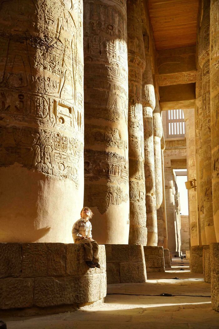 Child sitting among ancient Egyptian carved pillars discovery