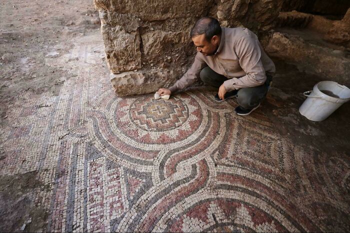 Archaeologist restoring intricate ancient mosaic floor from discoveries
