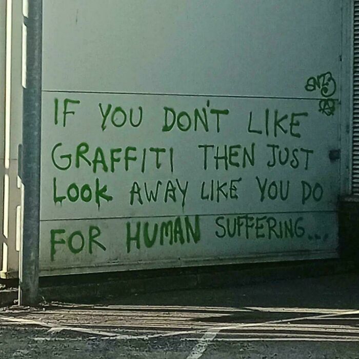 Graffiti on a wall saying If you don't like graffiti then just look away like you do for human suffering, a wild post.