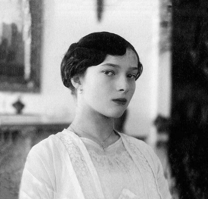 A historical photo of a young woman with a bob haircut and a thoughtful expression, an emotional and fascinating portrait.
