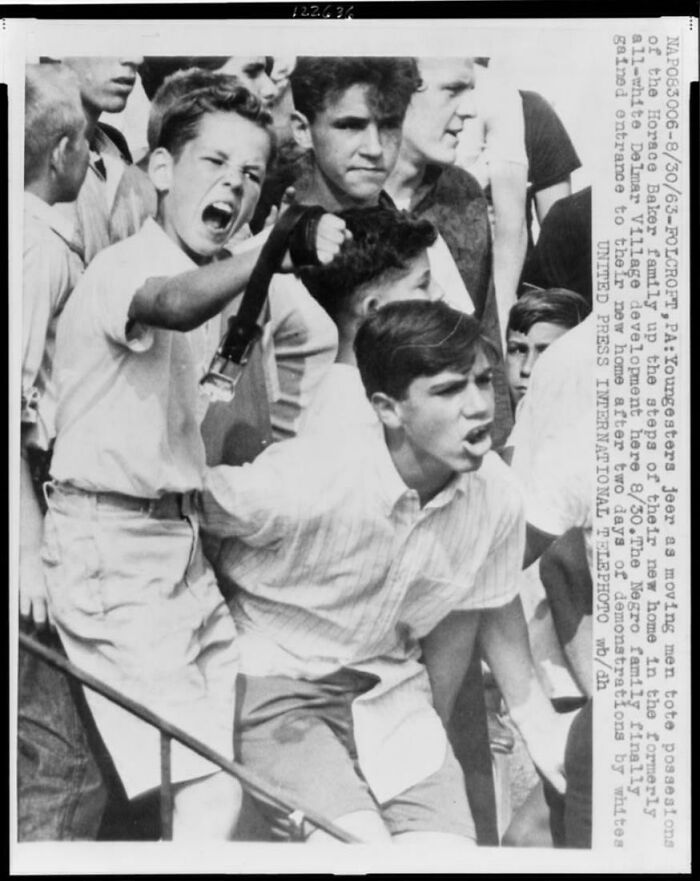 Young men shout aggressively at a historical event, captured in a fascinating historical photo.