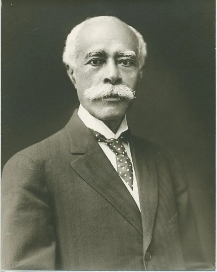 An emotional historical photo of Dr. George Clemenceau, a distinguished man with a mustache in formal attire.