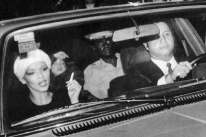 Emotional historical photos of a woman smoking in a car with a man driving and another passenger, showing the past.