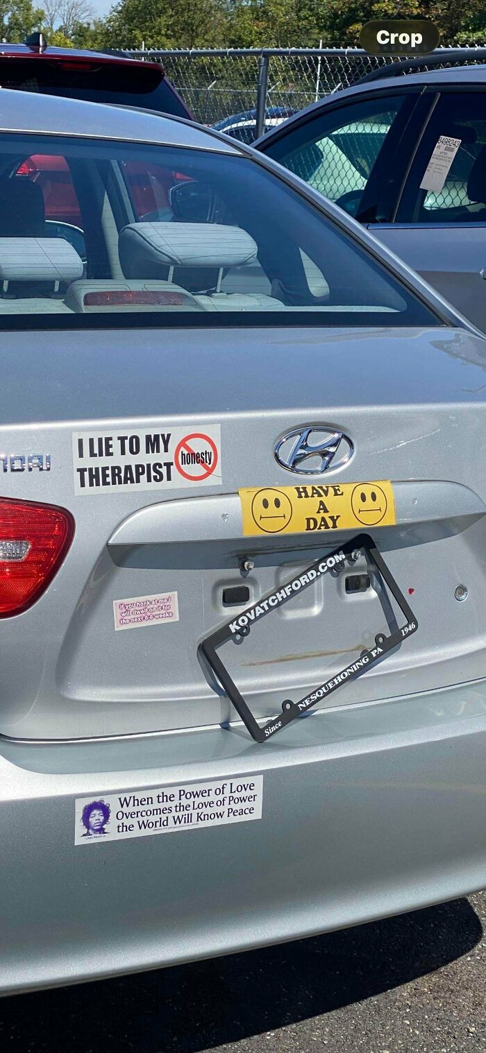 Various funny bumper stickers on a silver car, including I Lie To My Therapist, Have A Day, and Power Of Love.