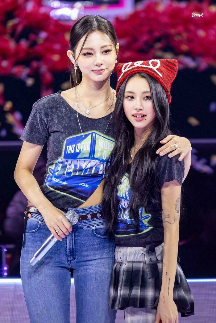 Two young women posing on stage with casual outfits, capturing a moment that seems like a misleading and confusing photo.
