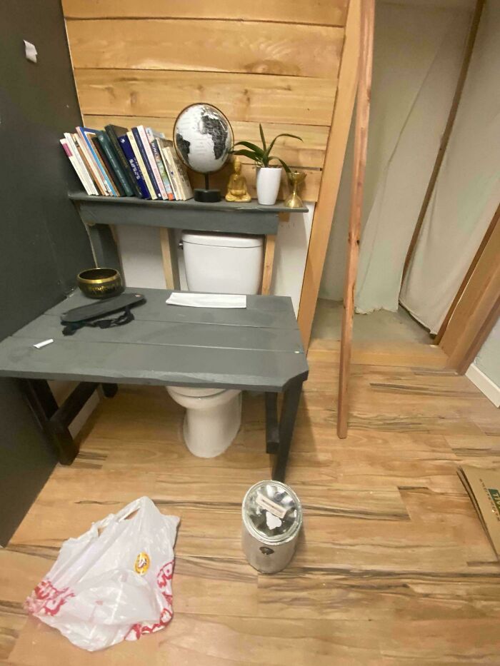 Bathroom toilet repurposed with a wooden desk cover in questionable DIY projects.