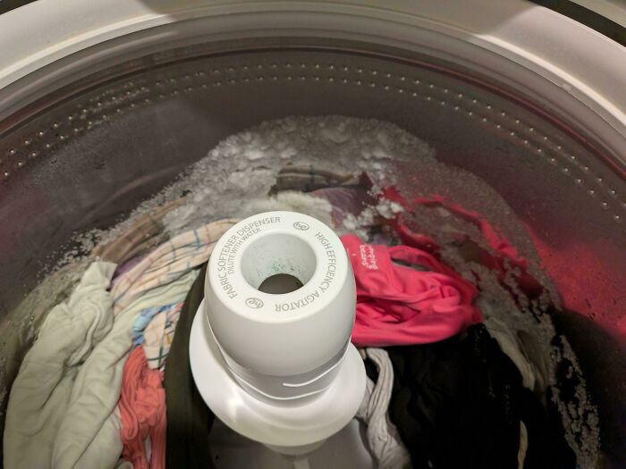 A top-down view inside a washing machine full of clothes, water, and detergent suds, for dads.