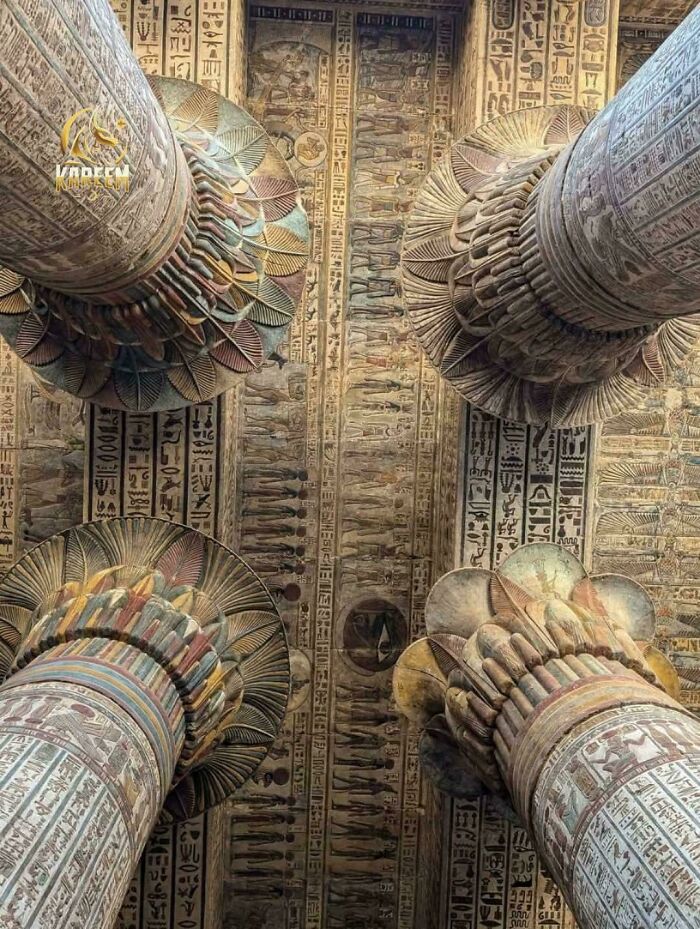 Looking up at ancient, intricately carved and painted columns and ceiling in an Egyptian temple, an interesting photo.