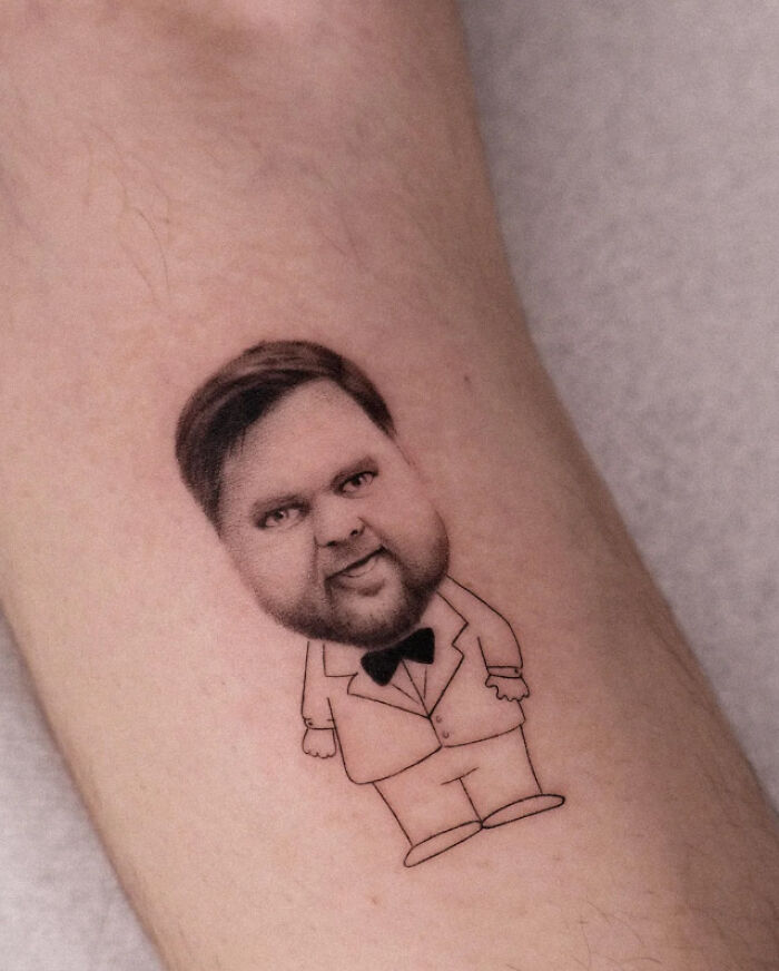 Cartoon-style leg tattoo of a man in a suit with a large head