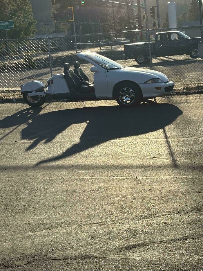 White car modified into a three-wheeled vehicle with open sides