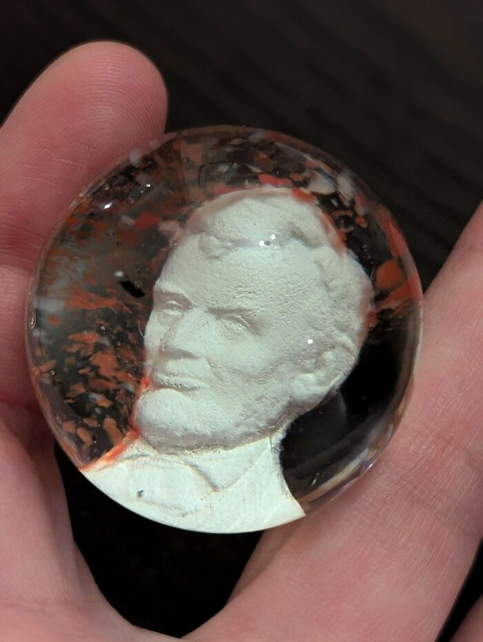Sculpted face inside clear resin sphere showing wasted skills in art