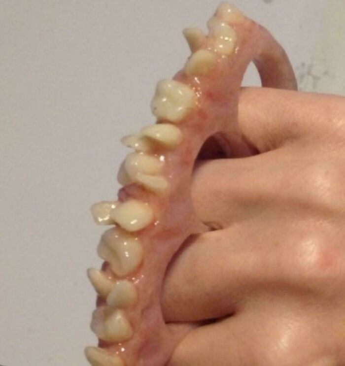 Close-up of a prosthetic hand with realistic teeth embedded on the fingers