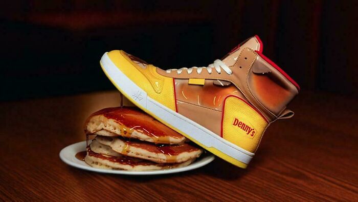 Shoe designed to look like pancakes with syrup, branded with Denny's logo
