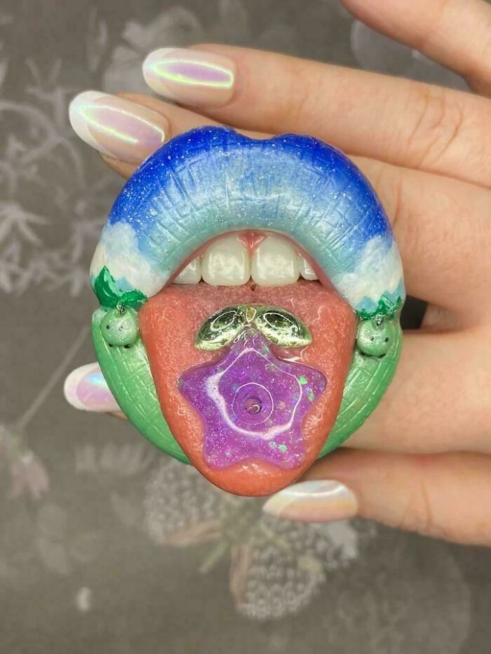 Creative art piece showing lips, tongue, and teeth with colorful nature design sculpture