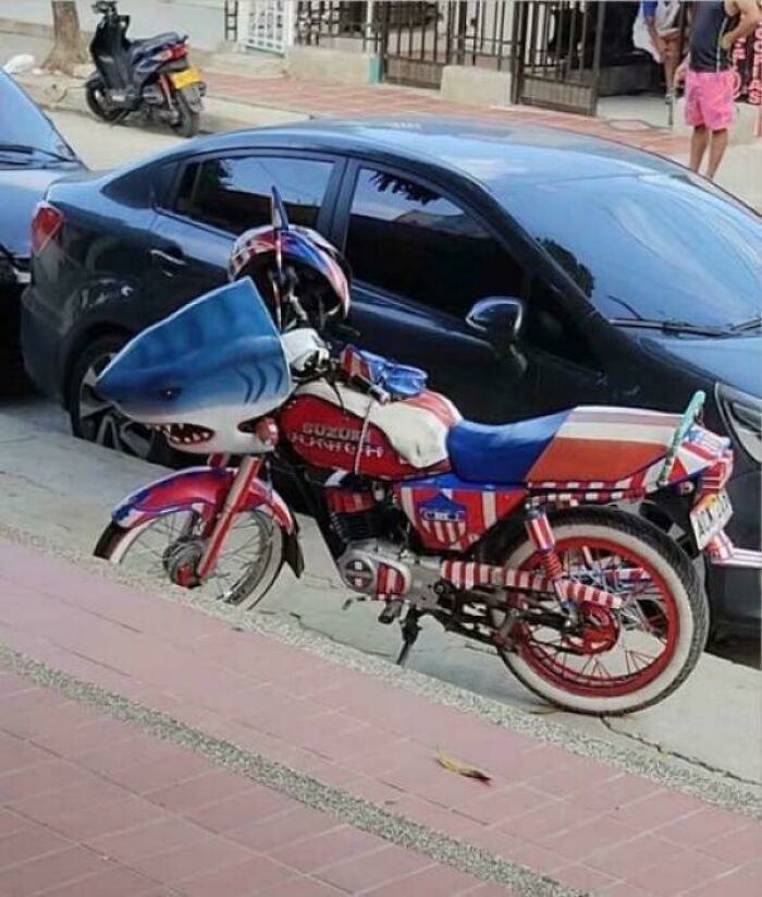 Motorcycle painted with shark and flag design displaying unusual craftsmanship