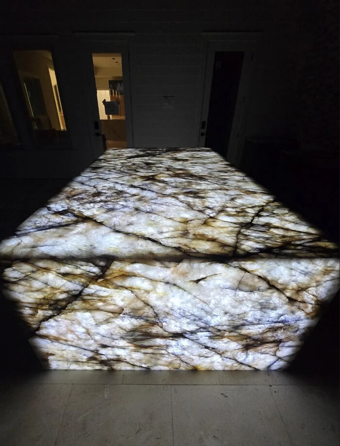 Illuminated slab of marble with glowing veined design at night