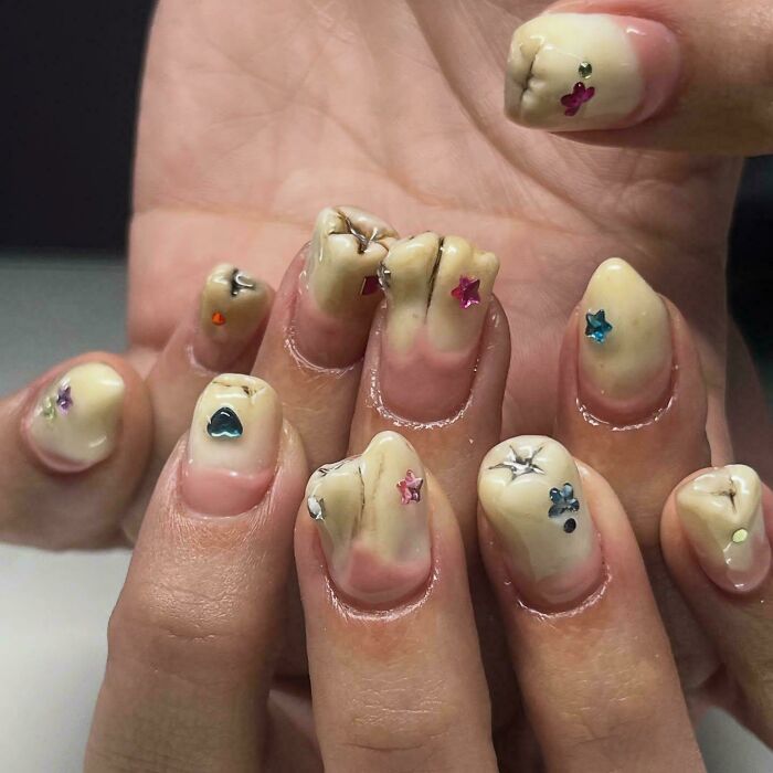 Nails designed to look like realistic teeth with gem decorations