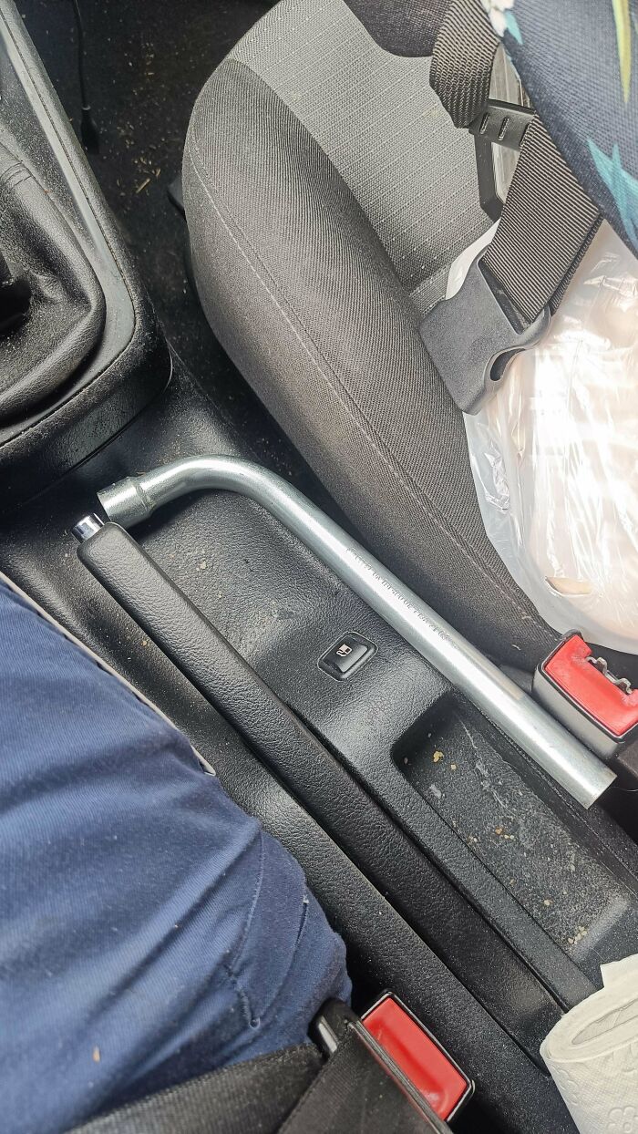 Lug wrench resting in a car interior, an unusual item car mechanics might find.