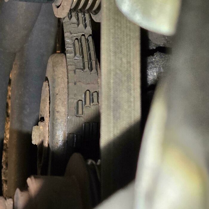 Worn-out car belt on a pulley, highlighting common issues car mechanics discover.