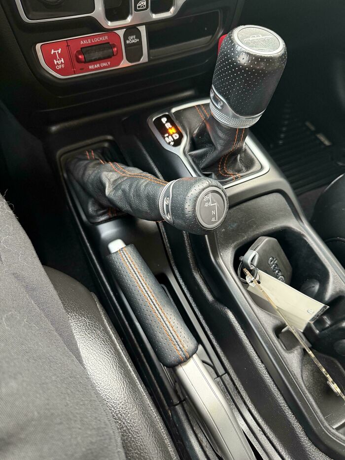 An interior view of a car, highlighting the gear shift and axle locker, showcasing what car mechanics deal with.
