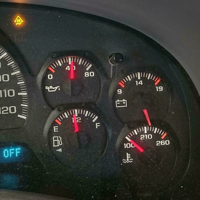 Car mechanics observe a vehicle dashboard with an illuminated warning light, indicating issues with car mechanics.