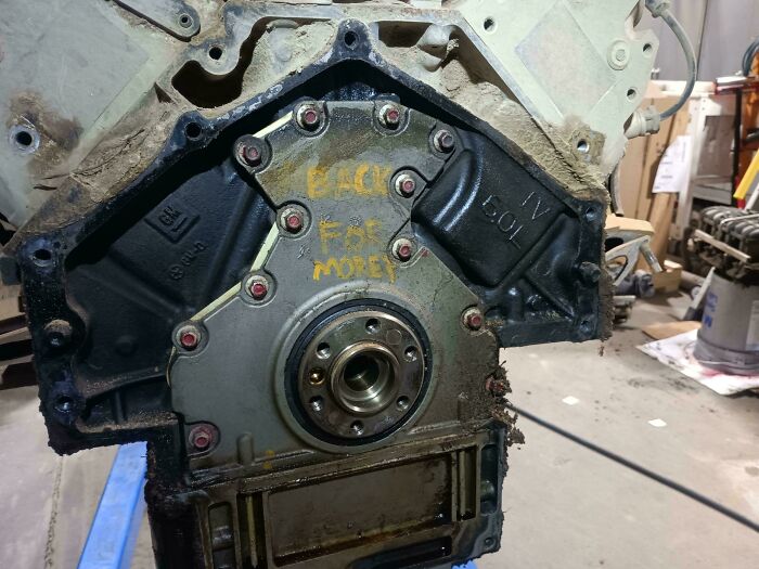 Car mechanics deal with a dirty engine block, showcasing the challenges of car repair and maintenance.