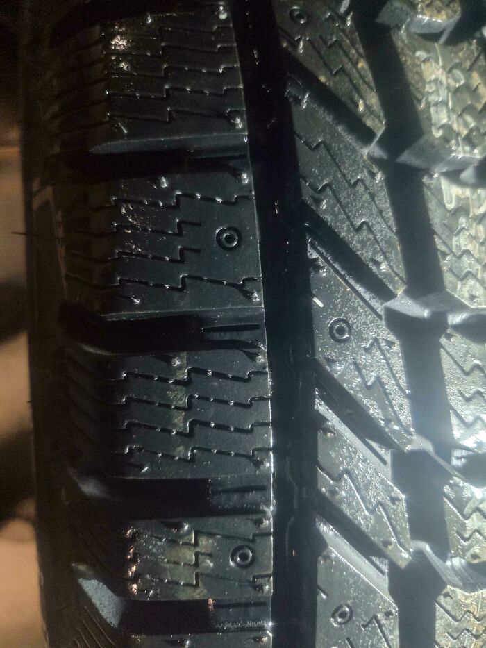 Close-up of a damaged car tire tread, highlighting the need for car mechanics intervention.