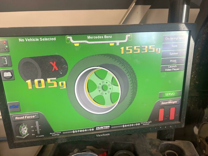 A car mechanic's screen showing a tire balancing machine with a Mercedes Benz tire, displaying 15535g and 105g readings.