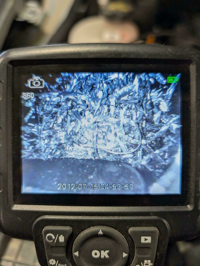 A screen displaying a close-up image of metal shavings and debris, a common sight for car mechanics.