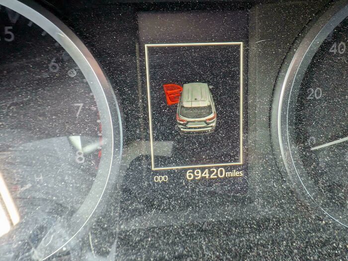 A car dashboard displaying 69,420 miles and a car icon with an open door, often seen by car mechanics.