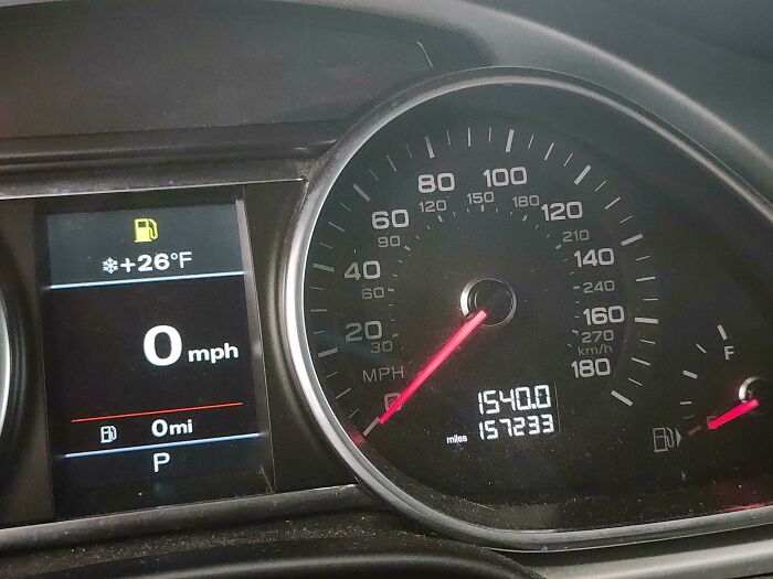 A car dashboard showing 154,000 miles and a fuel gauge, a common sight car mechanics deal with.