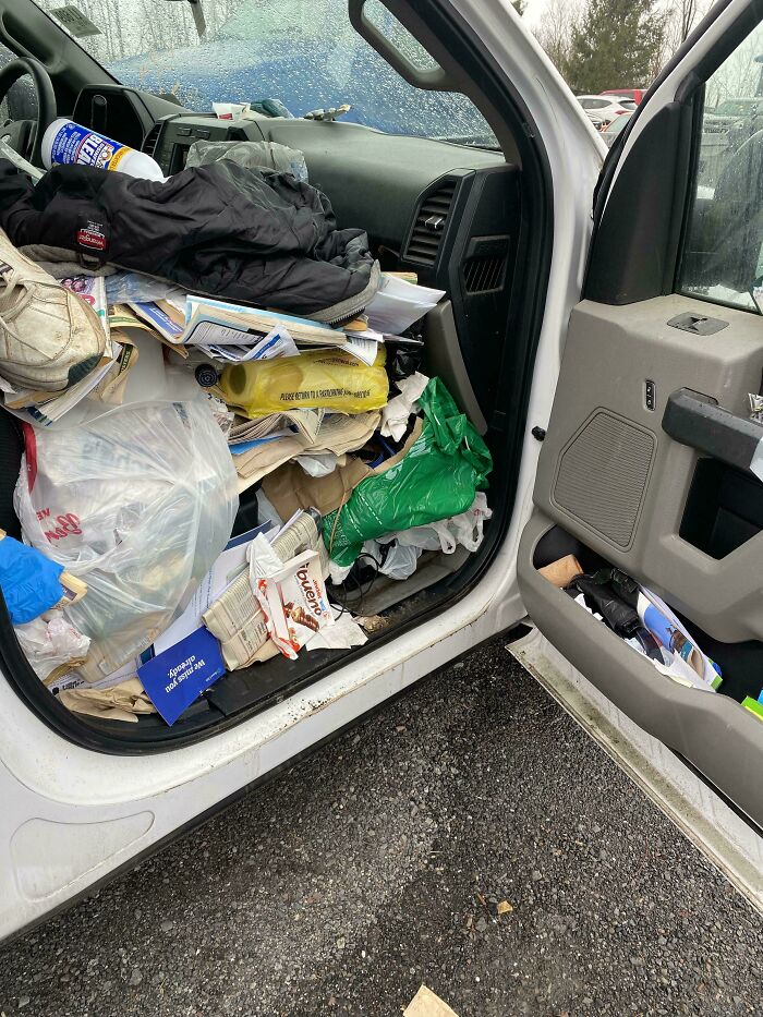 The interior of a car filled with an extreme amount of trash and clutter, a challenging situation for car mechanics.