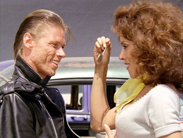 A candid historical photo showing a man and a woman smiling at each other, reliving days of romance.