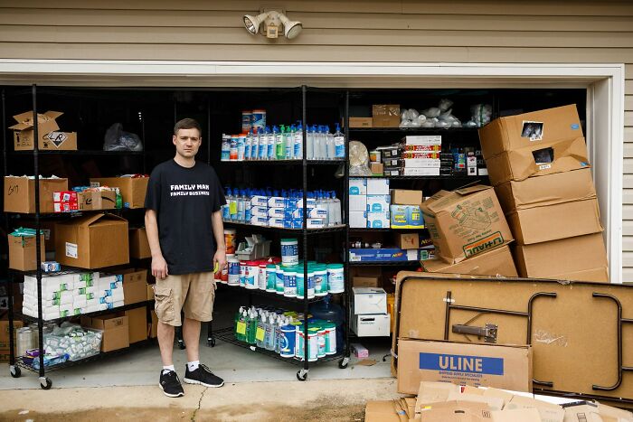 Young man standing in front of a cluttered garage filled with boxes and cleaning supplies, illustrating funny regret moments.