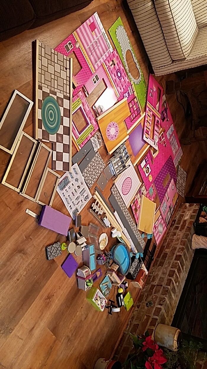 Unassembled dollhouse pieces scattered on floor showing a funny regret moment of a complex bad decision.