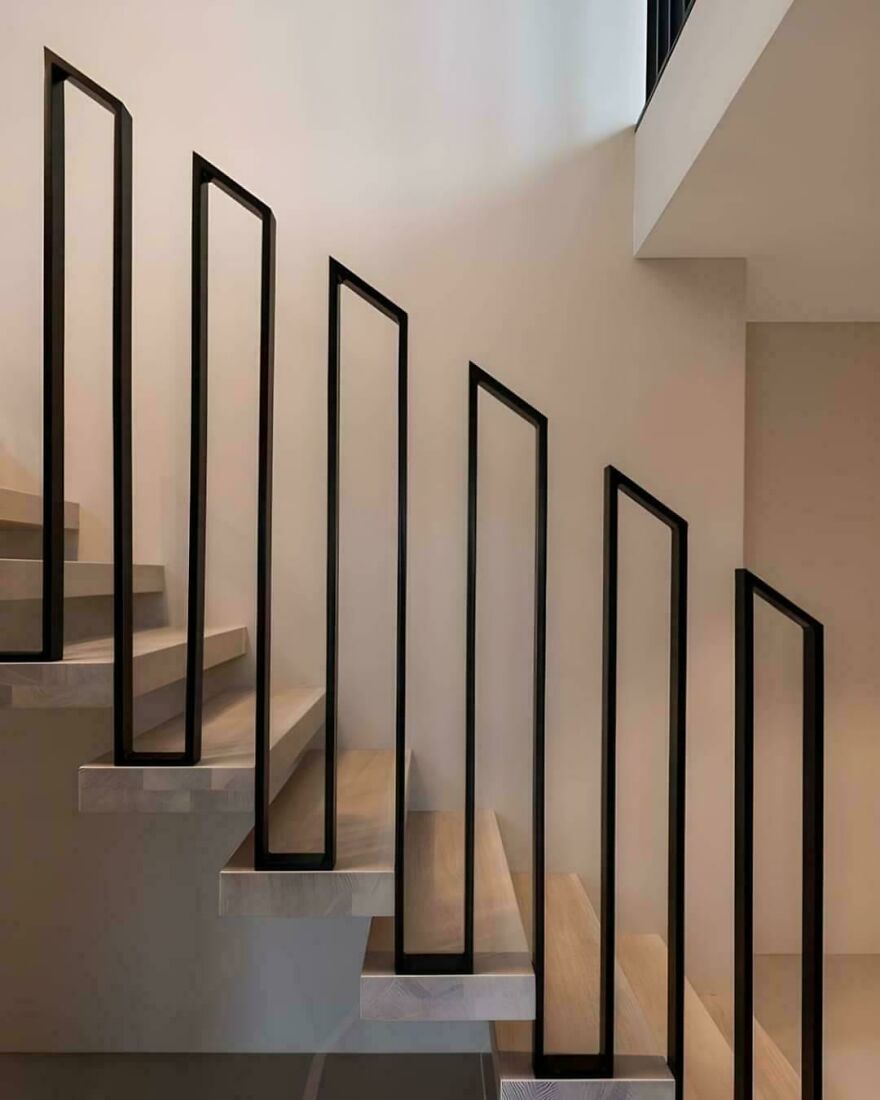 Modern staircase with minimalist black railings illustrating designers going too far and making things impossible to use.