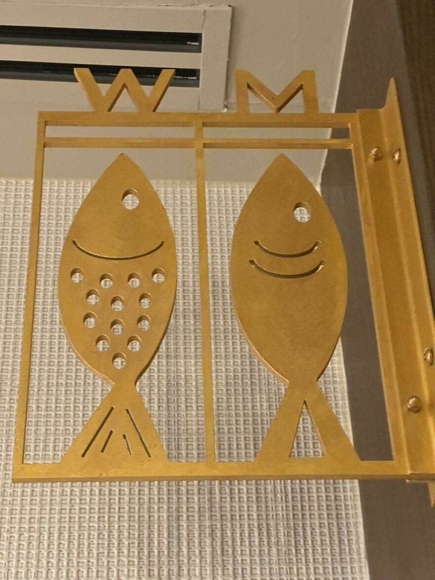 Metal sign with fish symbols labeled W and M, an example of designers went too far and made things impossible to use.